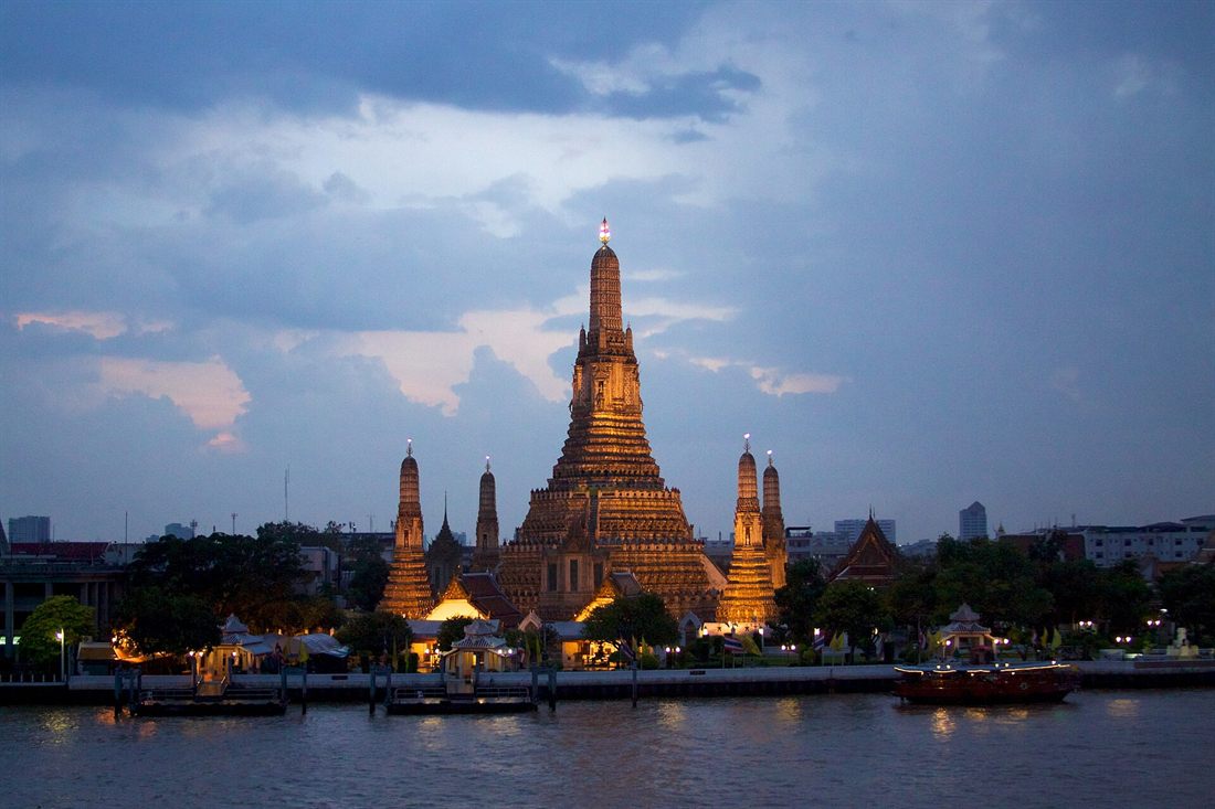 Wat Arun lit up at night on the Chao Phraya river in Bangkok